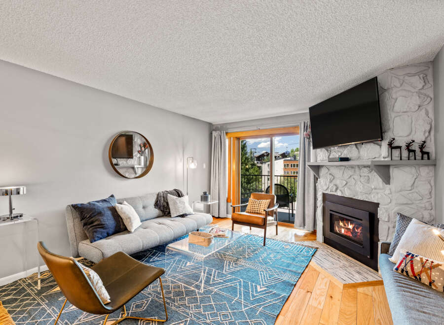 This inviting living room features a cozy fireplace with a mounted TV above, perfect for relaxing evenings.