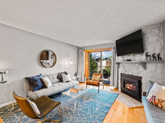 This inviting living room features a cozy fireplace with a mounted TV above, perfect for relaxing evenings.