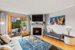 This cozy living room features a stone fireplace with a mounted TV, creating a warm focal point.