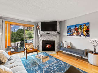 This cozy living room features a stone fireplace with a mounted TV, creating a warm focal point.