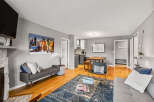 This inviting living space features hardwood floors, a cozy fireplace, and modern decor.