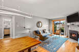 Step into this inviting condo featuring a cozy living space with a stone fireplace and a balcony offering scenic views.