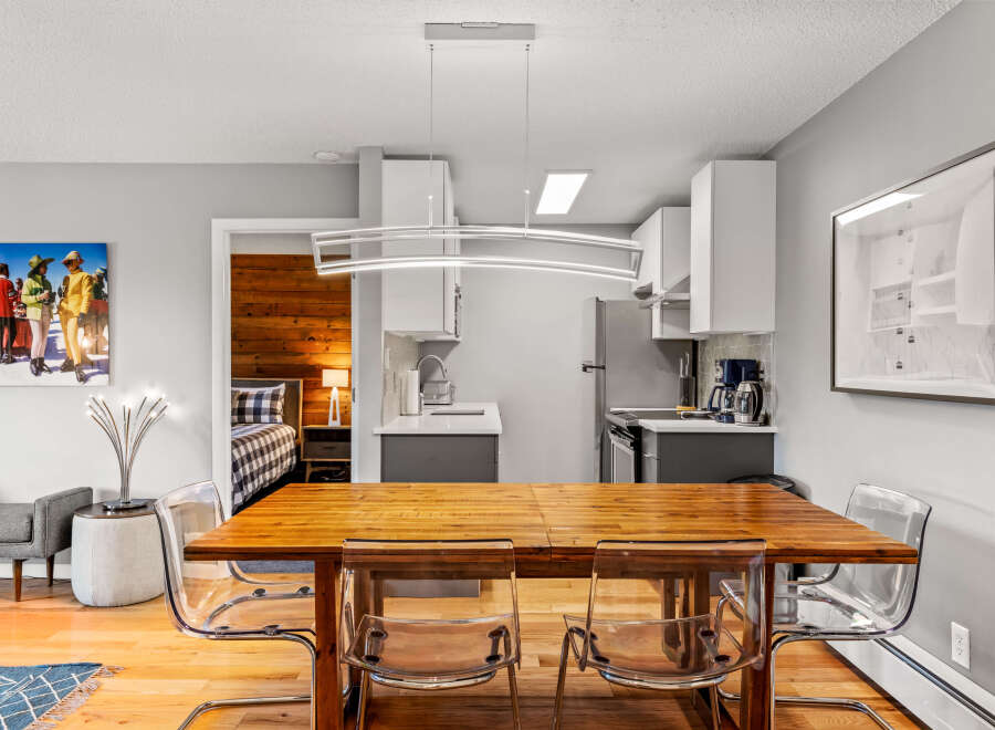 This inviting condo features a dining area with a wooden table and modern, transparent chairs, perfect for entertaining.