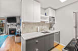 This cozy condo features a modern kitchen with white countertops, sleek gray cabinetry, and stainless steel appliances.