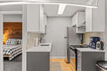 This compact kitchen boasts modern design with its sleek white cabinets and contrasting gray lower cabinets.