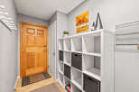 A welcoming entryway features a beautiful wood door, a functional storage unit with woven baskets, and stylish wall decor.