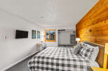This bedroom features a unique wood accent wall, adding warmth and character to the space.