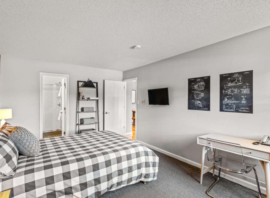 This bedroom offers a cozy retreat with its comfortable bed featuring a black and white checkered pattern.