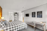 This bedroom offers a cozy retreat with its comfortable bed featuring a black and white checkered pattern.