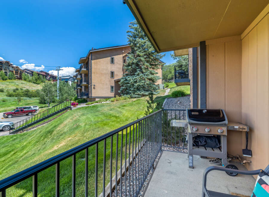 Enjoy outdoor living on this condo's private balcony featuring a grill.
