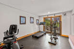 This home gym boasts a treadmill, elliptical machine, and stationary bike for convenient workouts.