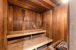 Indulge in the luxury of this home sauna, featuring beautiful wood paneling and comfortable tiered seating.
