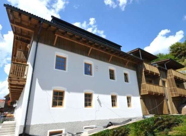 This stunning property boasts a unique architectural design, featuring a combination of wood and modern elements.