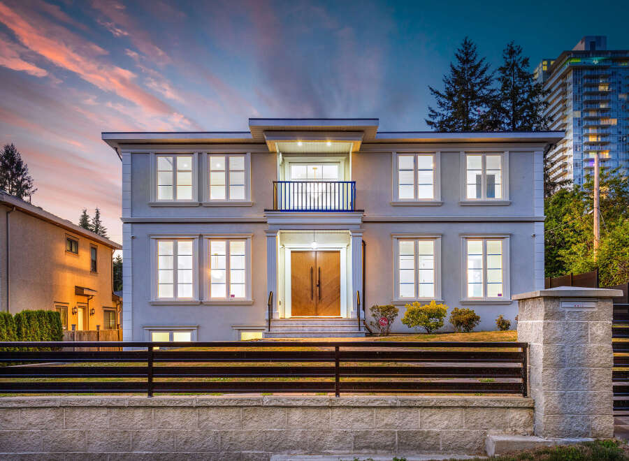 This stunning two-story home features a modern design with large windows and a charming balcony.