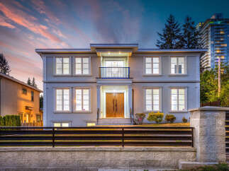 This stunning two-story home features a modern design with large windows and a charming balcony.