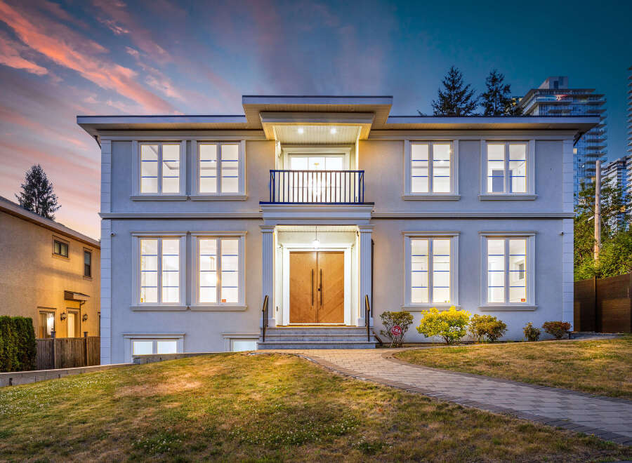 This is a two-story house boasts a stunning exterior with a balcony, complemented by a meticulously maintained lawn.