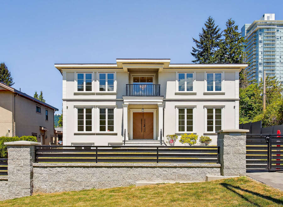 This is a stunning two-story house with a modern design, featuring large windows that offer plenty of natural light.