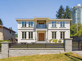 This is a stunning two-story house with a modern design, featuring large windows that offer plenty of natural light.