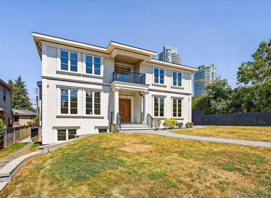 This stunning two-story house boasts a modern design with large windows, offering plenty of natural light.