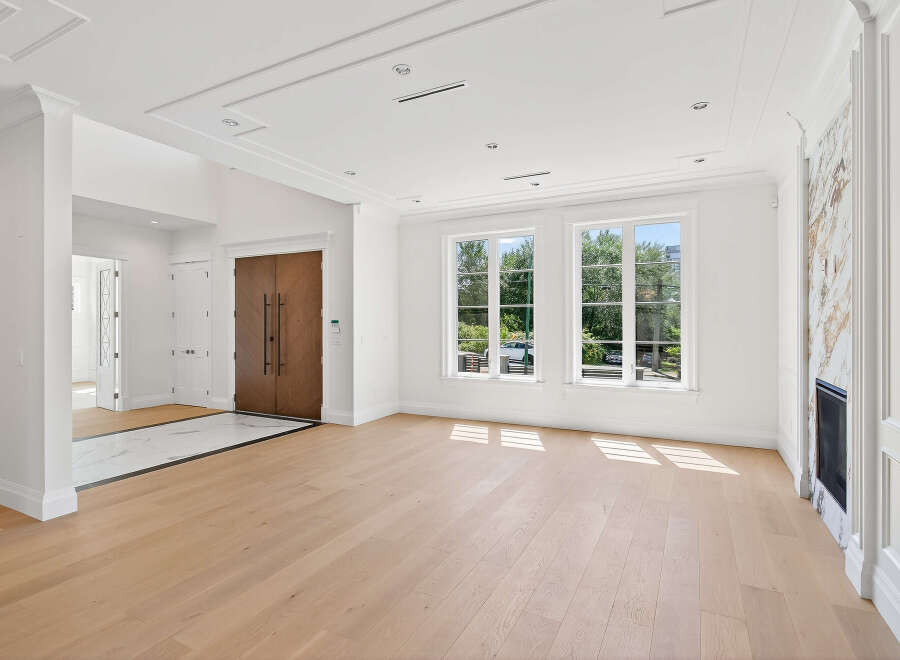 Step into this bright and airy living space, featuring elegant hardwood floors and abundant natural light streaming through large windows.