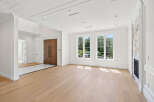Step into this bright and airy living space, featuring elegant hardwood floors and abundant natural light streaming through large windows.