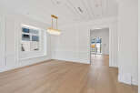 Step into this bright and airy room featuring exquisite millwork, a stunning crystal chandelier, and beautiful hardwood floors.