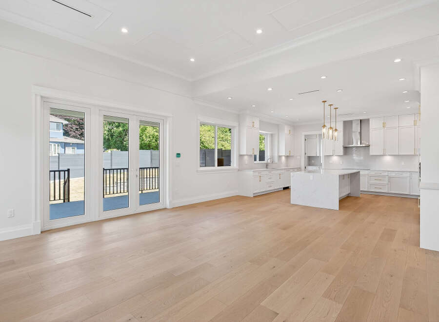 This is a bright and airy open-concept living space featuring a modern kitchen with a large island and stainless steel appliances.