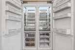 This is a modern, built-in refrigerator with a sleek white interior and stainless steel accents.
