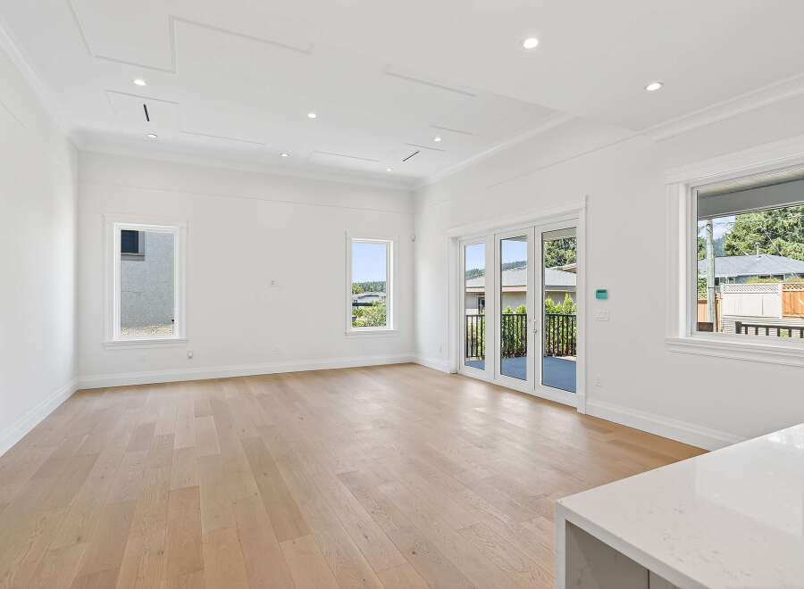 This is a bright, spacious living area with hardwood floors and white walls, perfect for modern living.