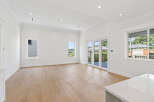 This is a bright, spacious living area with hardwood floors and white walls, perfect for modern living.