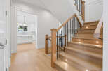 This inviting home features a stunning staircase with wood treads and black metal railings, illuminated by subtle step lights.