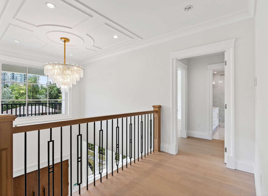 This home features a luxurious foyer with a stunning chandelier and grand staircase.