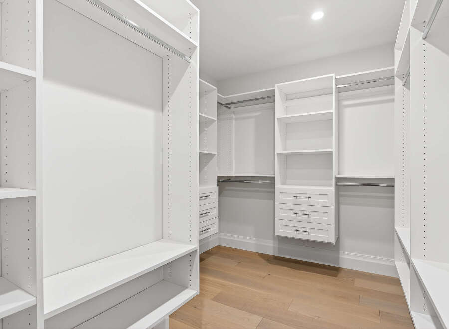 This is a spacious walk-in closet designed for optimal organization.
