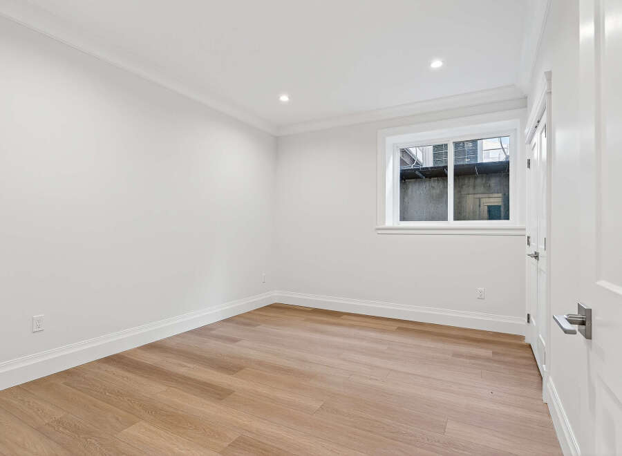 This bright and airy room boasts modern renovations, including new wood floors, fresh white paint, and updated trim.