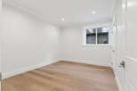 This bright and airy room boasts modern renovations, including new wood floors, fresh white paint, and updated trim.