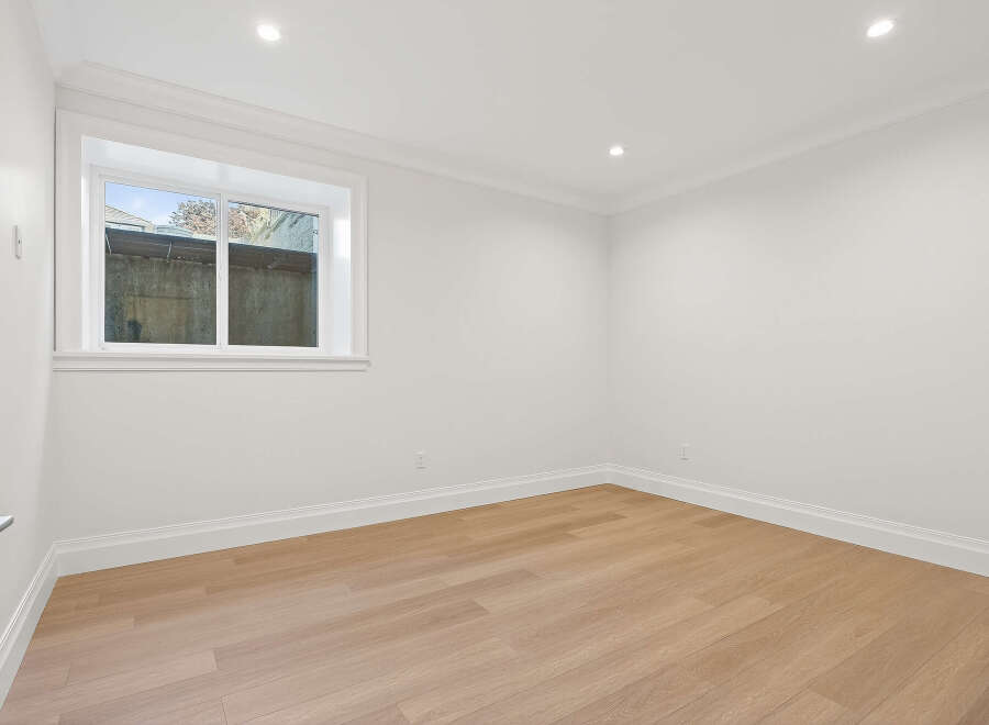 This is a bright and airy room with hardwood floors, white walls, and recessed lighting.