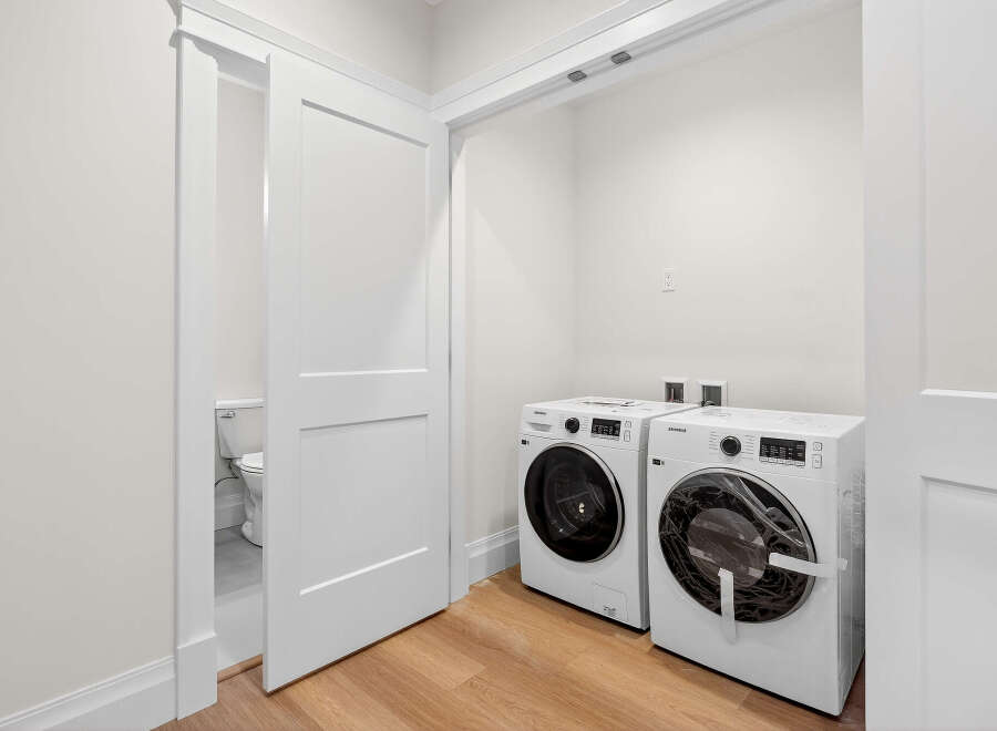 This bright and modern laundry room features a side-by-side Samsung washer and dryer set.