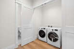 This bright and modern laundry room features a side-by-side Samsung washer and dryer set.
