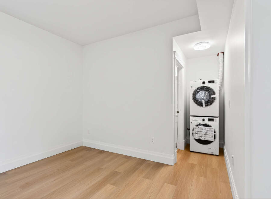This bright and modern room features neutral walls, beautiful wood floors, and convenient in-unit laundry.