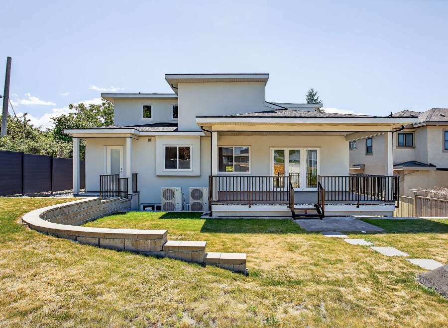 This property features a modern exterior design with a spacious backyard and a deck, perfect for outdoor entertaining.