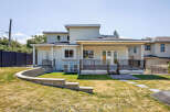 This property features a modern exterior design with a spacious backyard and a deck, perfect for outdoor entertaining.