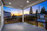 Enjoy outdoor living on this covered patio with sleek tile flooring and a stylish railing.