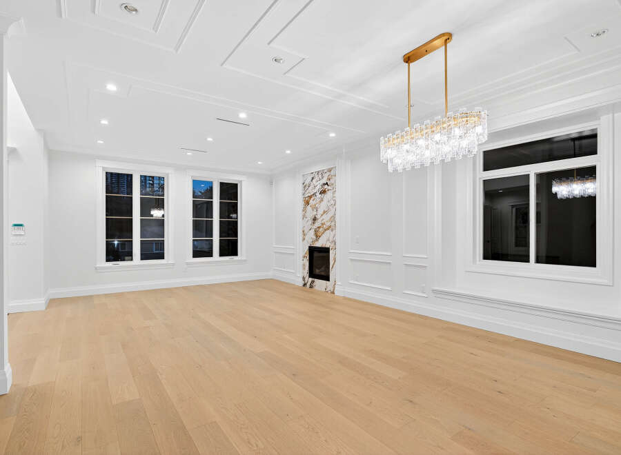 This elegant living room features pristine white walls, complementing the natural light that streams in through the large windows.