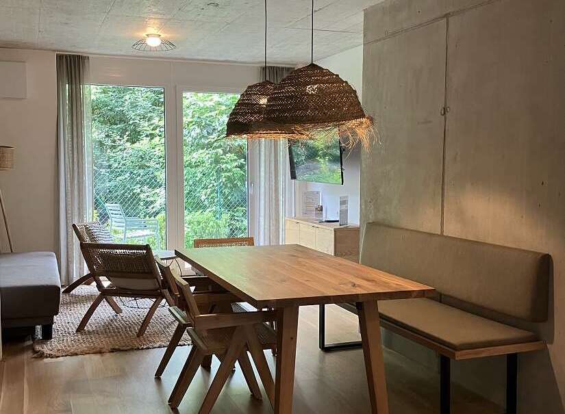 This inviting dining area features a wooden table paired with woven chairs and a comfortable bench, perfect for family meals or entertaining guests.