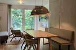 This inviting dining area features a wooden table paired with woven chairs and a comfortable bench, perfect for family meals or entertaining guests.