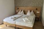 This inviting bedroom features a king-sized bed with a stylish wooden headboard, perfect for a relaxing stay.
