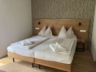 This inviting bedroom features a king-sized bed with a stylish wooden headboard, perfect for a relaxing stay.