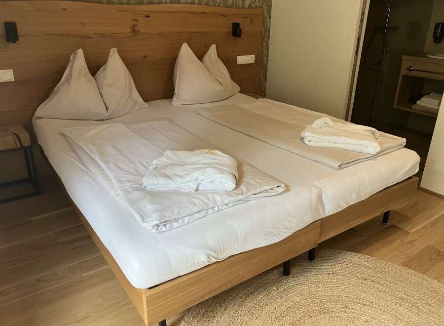 Experience ultimate comfort in this inviting hotel room, featuring a plush bed with crisp white linens and soft pillows.