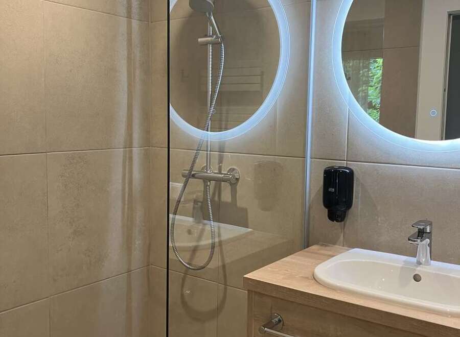 This modern bathroom features a walk-in shower with sleek glass enclosure, enhancing the sense of space.