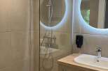 This modern bathroom features a walk-in shower with sleek glass enclosure, enhancing the sense of space.